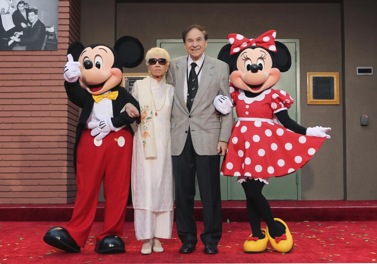 ARCHIVO - Mickey Mouse, de izquierda a derecha, Elizabeth Gluck, Richard M. Sherman y Minnie 
