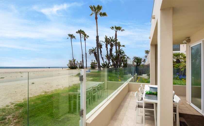 The two-story condo offers ocean views from a patio and balcony.