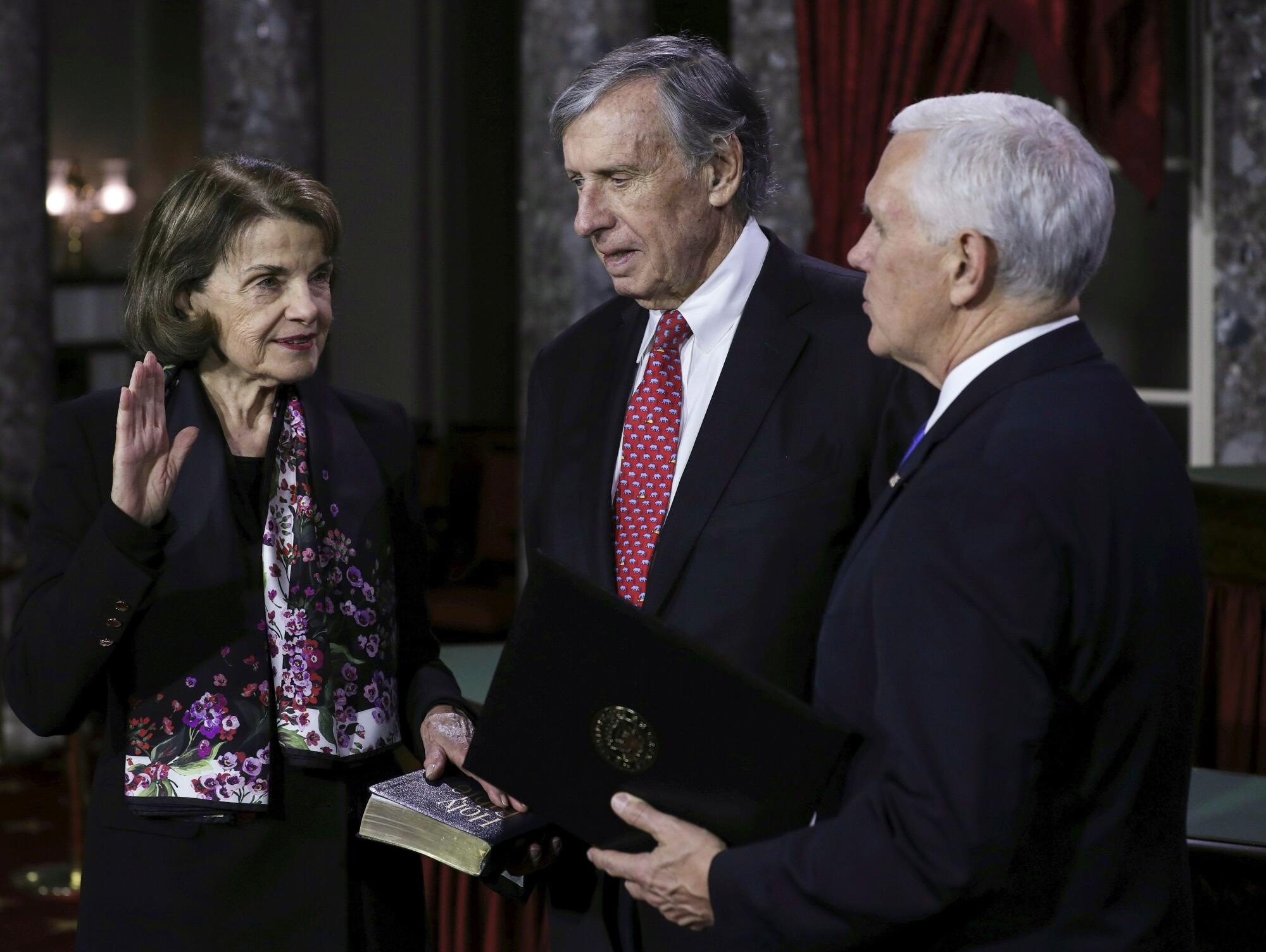 Sen. Dianne Feinstein, standing with husband Richard Blum and Vice President Mike Pence, raises her right hand for an oath