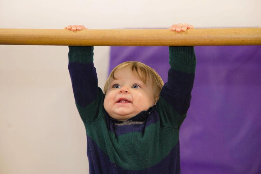 A young gymnast practices a pull-up at G3Kids Gym.