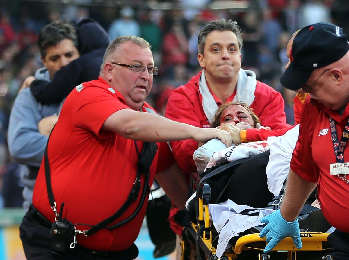 A fan who was seriously injured when she was struck by a broken bat is taken out of Fenway Park on Friday night.