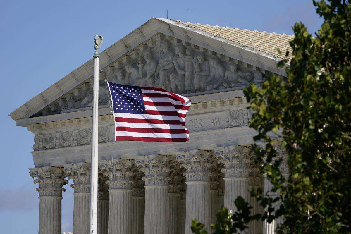  An American flag blows in the wind in front of the Supreme Court.