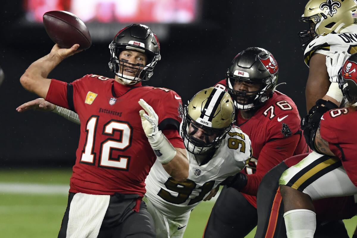 Tampa Bay Buccaneers quarterback Tom Brady is pressured by New Orleans Saints defensive end Trey Hendrickson.