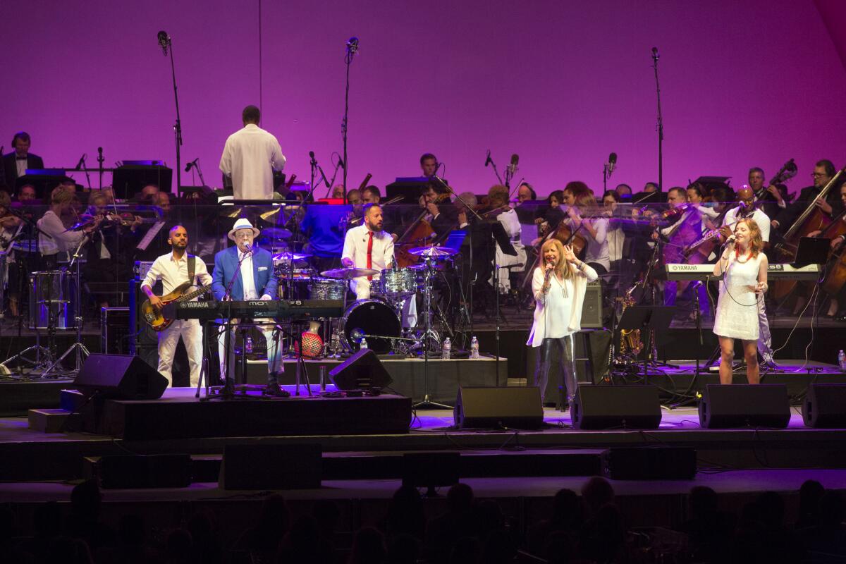 Sergio Mendes, at keyboard, leads his band and the Hollywood Bowl Orchestra on Friday night.