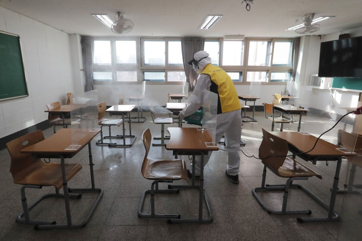 A worker disinfects a test center as a coronavirus precaution for the upcoming college entrance exams in Seoul.