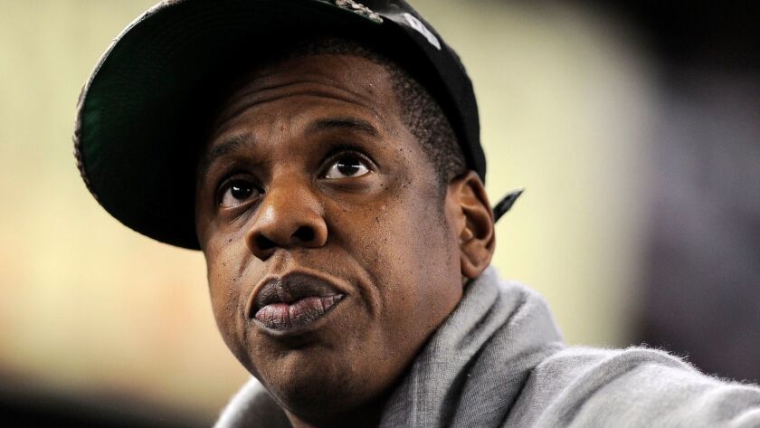Music mogul Jay-Z watches a baseball game at Yankee Stadium in 2011. Sociologist and prolific author Michael Eric Dyson will honor Jay-Z's 50th birthday with a book examining the hip-hop legend.