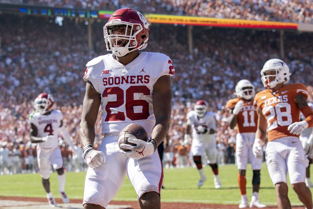 Oklahoma running back Kennedy Brooks (26) runs in for a touchdown against Texas during the fourth quarter of an NCAA college football game at the Cotton Bowl, Saturday, Oct. 9, 2021, in Dallas. Oklahoma won 54-48. (AP Photo/Jeffrey McWhorter)