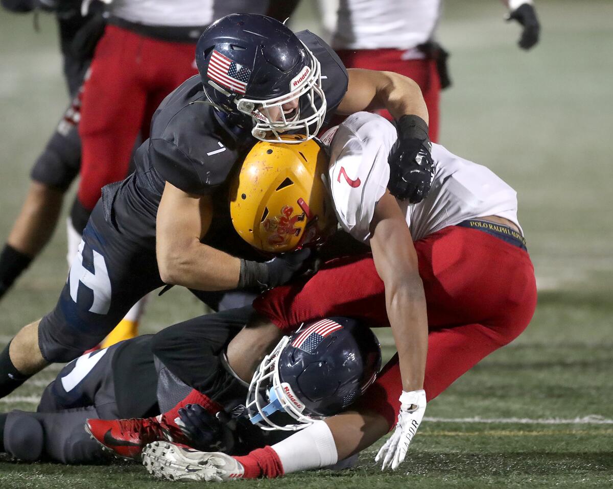 Newport Harbor linebacker Conner Chenier (7) stops Compton Dominguez running back Taylor Woods for a loss.