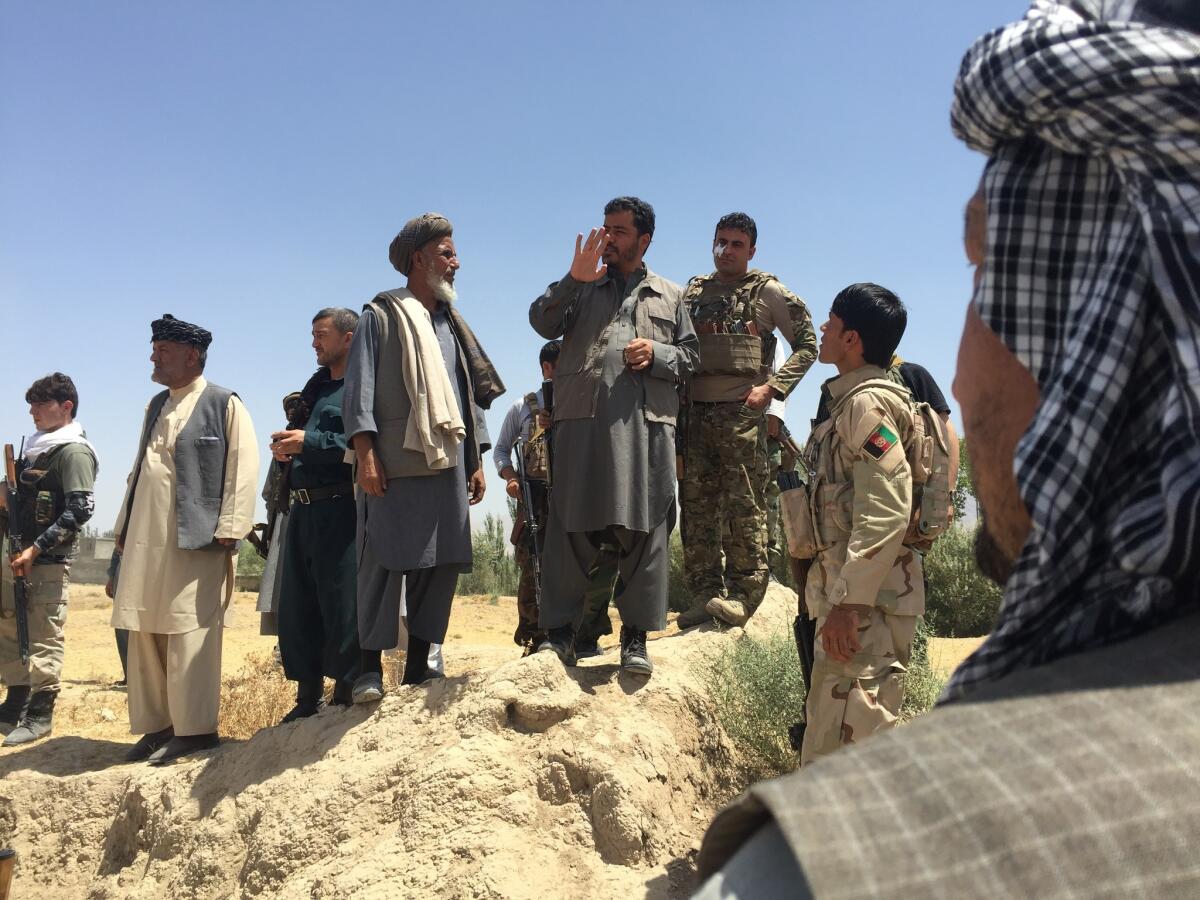 Yasin Zia, governor of Takhar province in Afghanistan, center, talks to militiamen outside Eshkamesh, Afghanistan, in July.