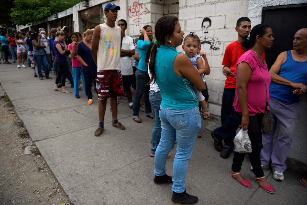 Venezuelans line up to buy bread outside a store in Caracas on May 17, 2016.