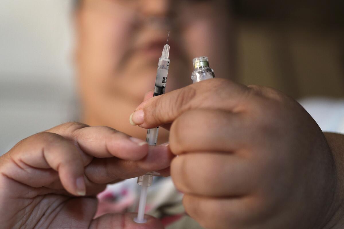 A woman with Type 2 diabetes prepares to inject herself with insulin