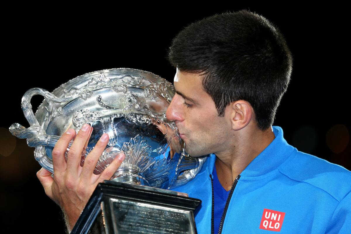 Novak Djokovic gives the winner's trophy a kiss after defeating Andy Murray in the Australian Open championship match on Sunday in Melbourne.