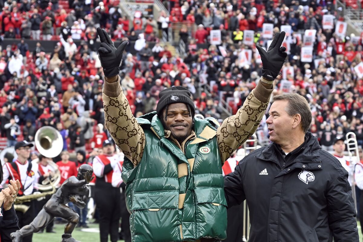 Lamar Jackson waves to the crowd during a ceremony retiring his number of his number at the University of Louisville in Louisville, Ky., Saturday, Nov. 13, 2021. (AP Photo/Timothy D. Easley)