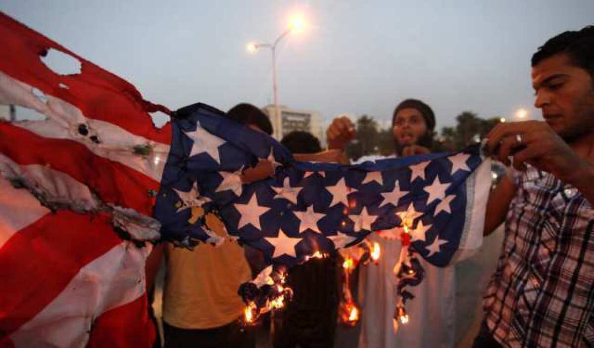 Protesters burn an American flag in Benghazi, Libya, where a mob this month killed four U.S. Americansl, including Ambassador J. Christopher Stevens.