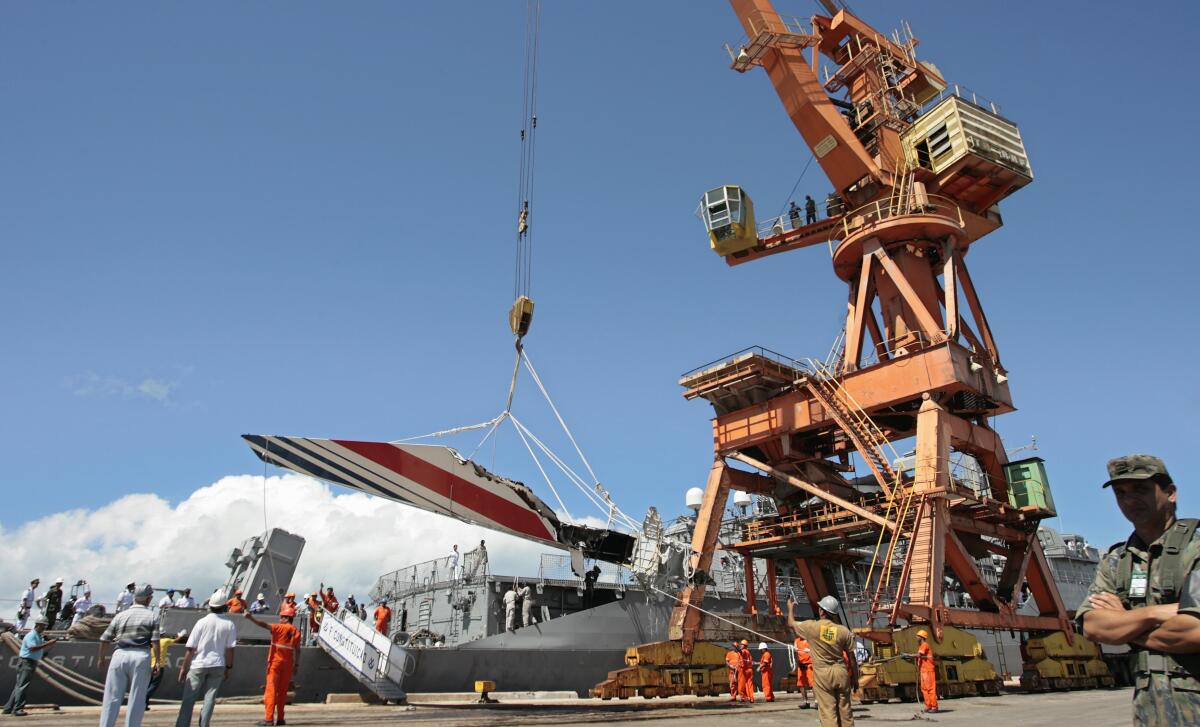 FILE - Workers unload debris, belonging to the crashed Air France flight AF447, from the Brazilian Navy's Constitution Frigate in the port of Recife, northeast of Brazil, June 14, 2009. It was the worst plane crash in Air France history, killing people of 33 nationalities and having lasting impact. It led to changes in air safety regulations, how pilots are trained and the use of airspeed sensors. (AP Photo/Eraldo Peres, File)