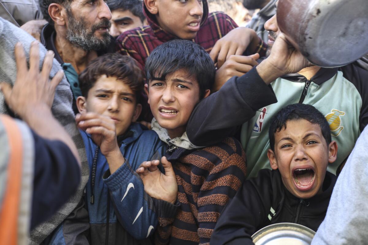 Palestinos esperan para recibir comida en Rafa,