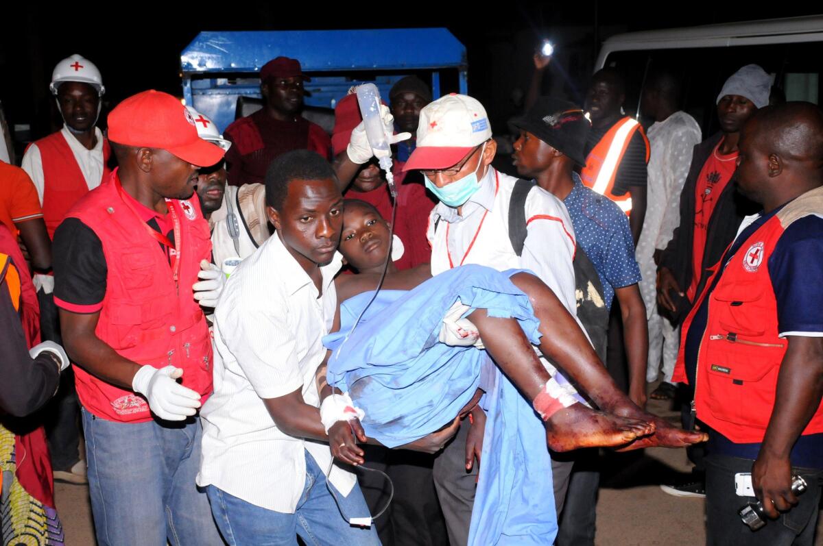Rescue workers carry an injured victim of twin bombings in the Nigerian city of Jos to a hospital on Dec. 11.