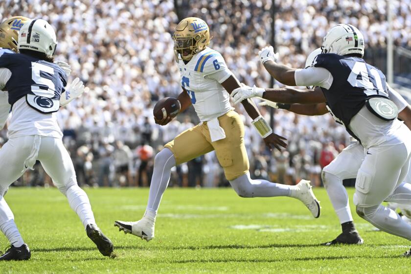 UCLA quarterback Justyn Martin (6) looks to elude Penn State linebacker Kobe King (41) on a run during the second quarter of an NCAA college football game, Saturday, Oct. 5, 2024, in State College, Pa. (AP Photo/Barry Reeger)