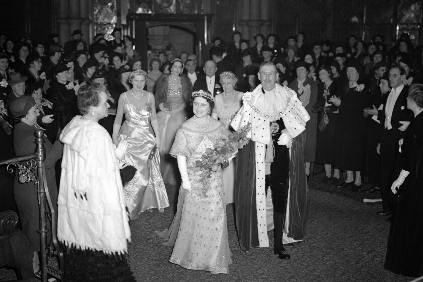 FILE - In this March 28, 1939 file photo, Britain's Queen Elizabeth with the Lord Mayor of London passes through the Council Chamber of the Guildhall to attend a party and reception in aid of the National Birthday Trust Fund in the Guildhall, London, after receiving purses from debutantes and peeresses. Prince Philip was the longest serving royal consort in British history. In Britain, the husband or wife of the monarch is known as consort, a position that carries immense prestige but has no constitutional role. The wife of King George VI, who outlived him by 50 years, was loved as the Queen Mother. (AP Photo/Leslie Priest, File)