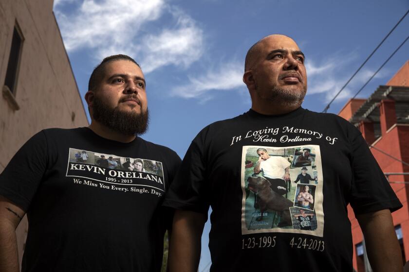 PASADENA, CA -JULY 02, 2021: Guillermo Orellana, 33, left, and his father Pedro Orellana, 53, wearing shirts in tribute to their brother and son respectively, Kevin Orellana, who was murdered at the age of 18, back in 2013, are photographed in Pasadena. Two suspects were convicted of second degree murder. One of them was 16 years old at the time, but was sentenced as an adult and given 16 years to life. He was recently re-sentenced as a juvenile under one of D.A. George Gascon's policies. So far, he has served only 8 years, but could be released soon because of this change. (Mel Melcon / Los Angeles Times)