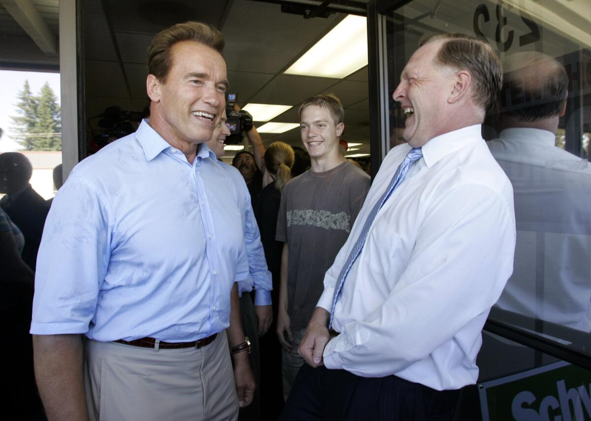 Former California Gov. Arnold Schwarzenegger, left, smiles with Duf Sundheim, right, former chairman of the California Republican Party, at Schwarzenegger's campaign office in Mountain View, Calif. on July 13, 2006.