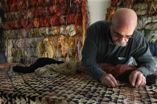 Hratch Kozibeyokian matches yard color to a rug he's repairing at Ko 'Z' Craft, his studio in the San Fernando Valley community of Shadow Hills. Kozibeyokian's studio has gained a following for museum-quality repairs. Home-dyed wool in a subtle rainbow of shades fills an entire wall of one workshop. Each indigo-, madder- and onion skin-tinted skein is actually a mix of dozens of blues, roses or golden-browns.