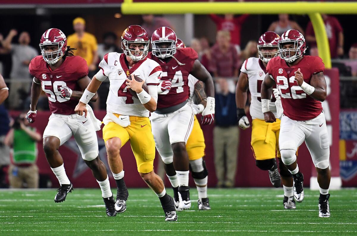 USC quarterback Max Browne picks up some yards while being pursued by the Alabama defense in the first quarter Saturday.