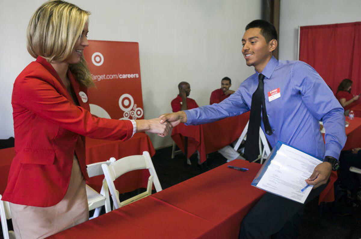 Target senior merchandiser Lauren Glasenapp welcomes prospective job candidate Daniel Martinez at a Target job fair in Los Angeles this week.