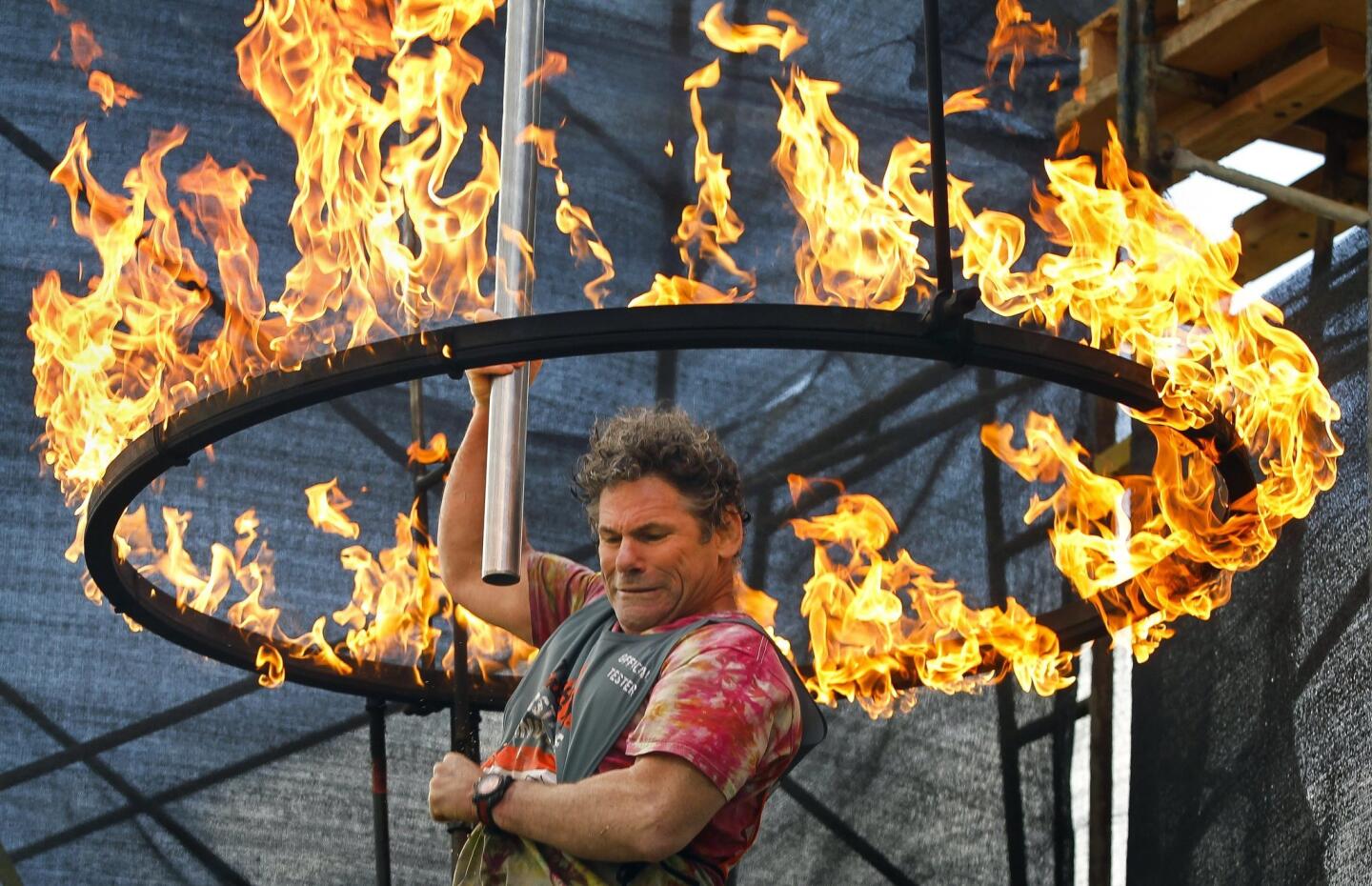 Roy Wallack, from Irvine, slides through the Ring of Fire as he and other volunteers tryout new features during the Tough Mudder Beta Test in Temecula on Saturday, November 1, 2014.