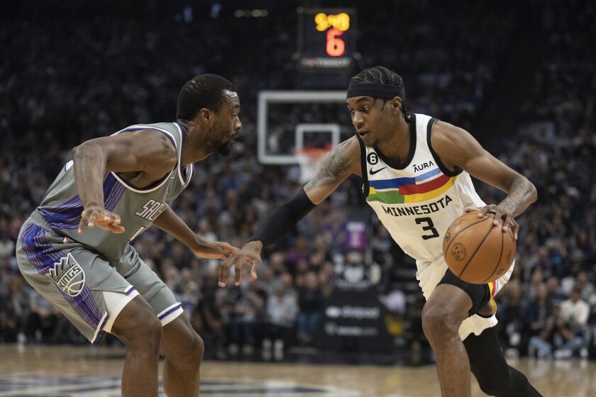 El jugador de los Kings de Sacramento Harrison Barnes, a la izquierda, defiende contra el jugador de los Timberwolves de Minnesota, Jaden McDaniels (3), en el tercer cuarto, en un juego de NBA en Sacramento, California, el lunes 27 de marzo de 2023. (AP Foto/José Luis Villegas)