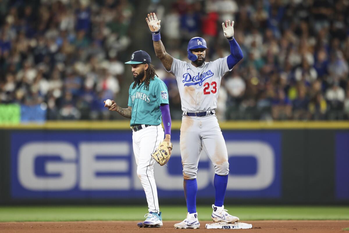 Dodgers' Jason Heyward celebrates in front of Seattle shortstop J.P. Crawford after hitting a double.