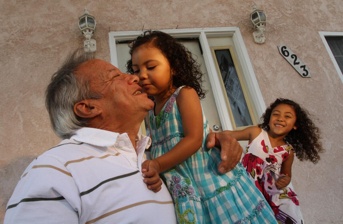 Fidel Lopez, playing with grand daughters Rachael, and Summer, outside his residence in Torrance.