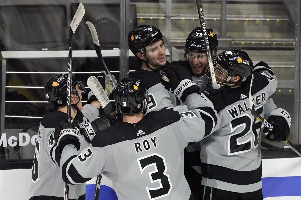 The Kings' Adrian Kempe, top middle, celebrates with teammates after scoring the winning overtime goal March 6, 2021.