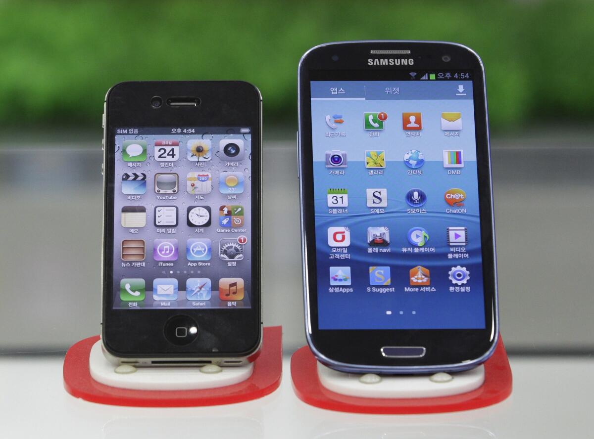 Samsung Electronics' Galaxy S III, right, and Apple's iPhone 4S displayed at a mobile phone shop in Seoul.