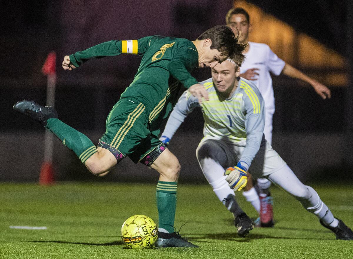 Edison's Nick Morrell takes a shot as Corona del Mar goalkeeper Nik Darrough comes out of the goal to attempt to block him during a Surf League match on Friday.