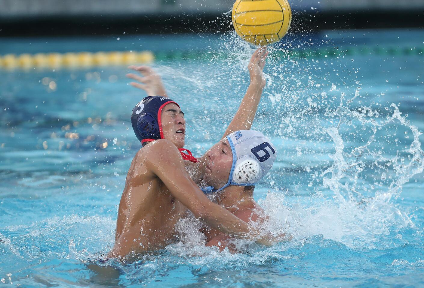 Beckman High's Keanu Pascual (3) lunges to block a shot by Corona Del Mar High's Matt Ueberroth in front of the net during wild-card round of the CIF Southern Section Division 2 playoffs at Beckman on Tuesday.