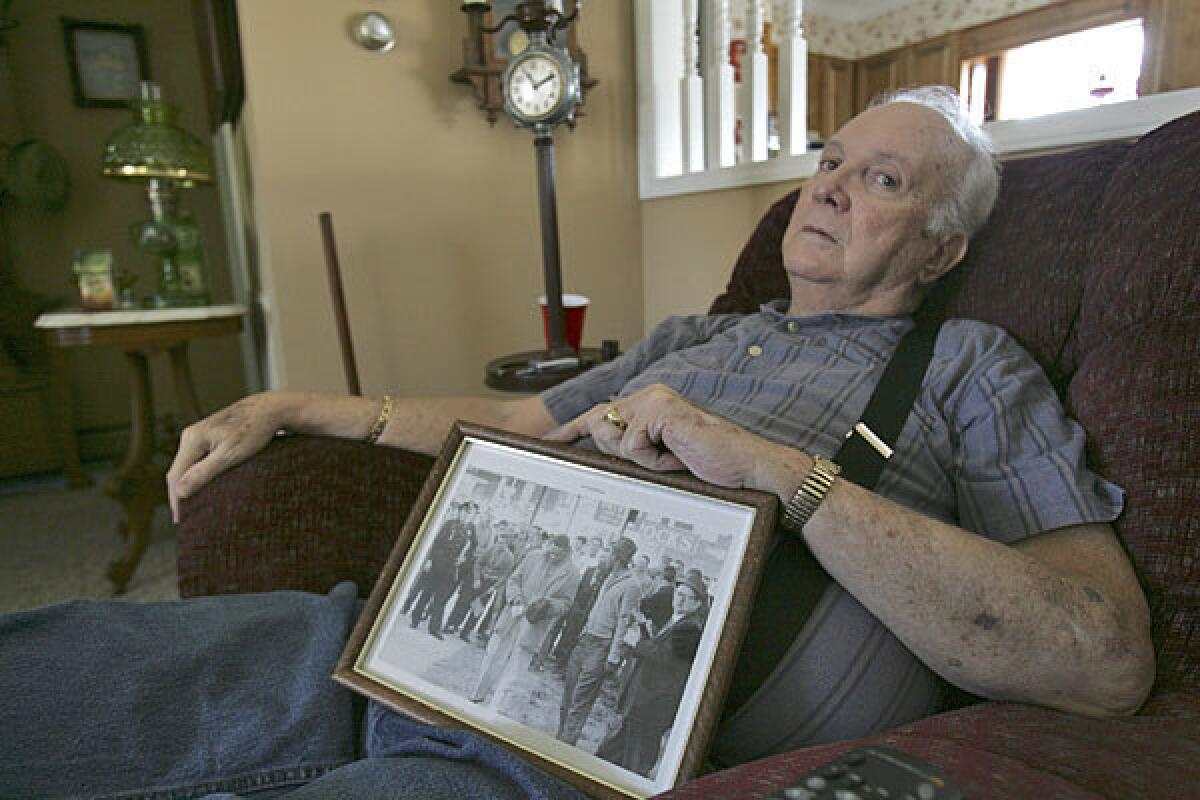 Elwin Wilson poses with a photo of a mob he participated in during a civil rights "sit-in" in Rock Hill, S.C.