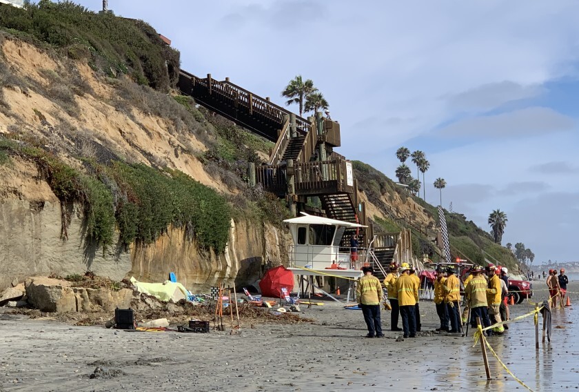 Rescue workers gather at the base of an Encinitas, Calif., beach bluff that collapsed.