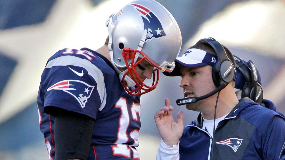 New England Patriots quarterback Tom Brady (12) confers with offensive coordinator Josh McDaniels during the first half of a game in Foxborough, Mass.