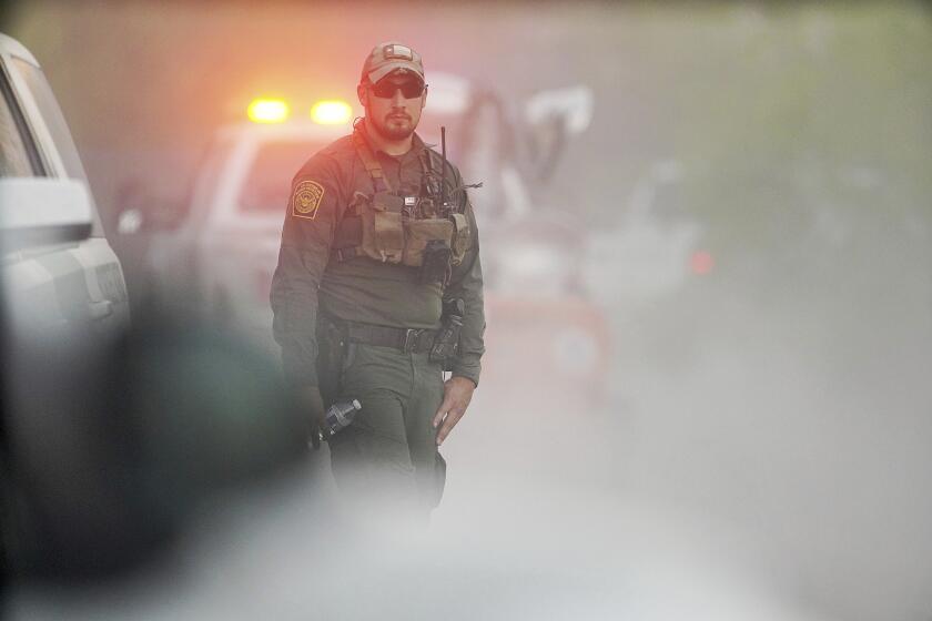 A U.S. Customs and Border Protections agent disappears into the dust as investigators drive to the site of a U.S. Border Patrol and CBP and Marine Operations helicopter resulting in three deaths north of the Rio Grande on Friday, March 8, 2024, south of La Grulla, Texas. (Joel Martinez/The Monitor via AP)