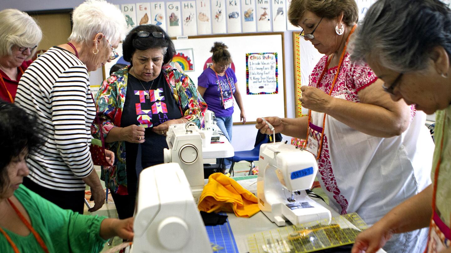 Gloria Molina, fourth from left, talks with Charlotte Lerchenmuller, third from left, about stitching during a quilting workshop at Centro Estrella in Los Angeles on Aug. 2.