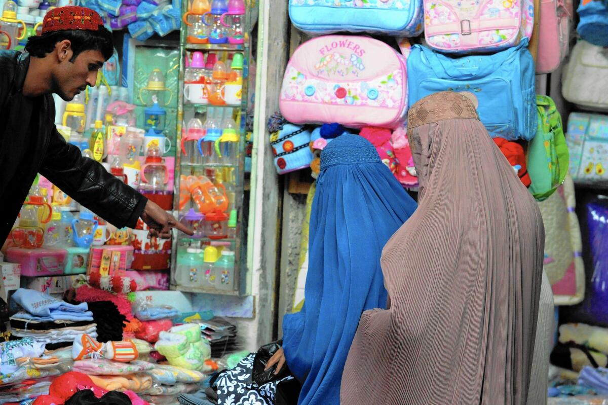 Burqa-clad Afghan women shop at a bazaar in Kandahar. With the official end of U.S. combat operations after 13 years of war, a federal auditor has concluded it is unclear how much Afghan women have benefited from U.S. efforts to help them or even how much has been spent on them.