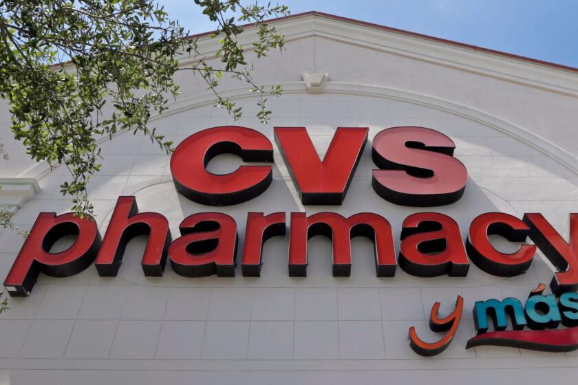 FILE - This May 15, 2017, file photo, shows a CVS pharmacy sign at a store in Hialeah, Fla. CVS will buy insurance giant Aetna in a roughly $69 billion deal that will help the drugstore chain provide more health care and keep a key client, according to a person with knowledge of the matter. (AP Photo/Alan Diaz, File)