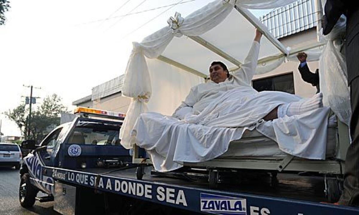 Manuel "Meme" Uribe, 43, is driven in a forklift to the dance hall where he and Claudia Solis will get married in Monterrey, Mexico, Sunday, Oct. 26, 2008. Uribe, who tipped the scales in 2006 at 1,230 pounds, earning him the Guinness Book of World Records' title for the world's heaviest man, lost 550 pounds (250 kilograms) with the help of Solis, whom he met four years ago.