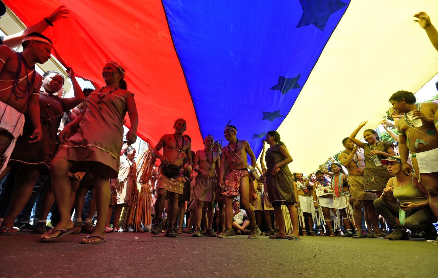 Venezuelan indigenous people take part in an opposition march in Caracas. Venezuela's opposition and government supporters head into a crucial test of strength with massive marches for and against a referendum to recall President Nicolas Maduro.