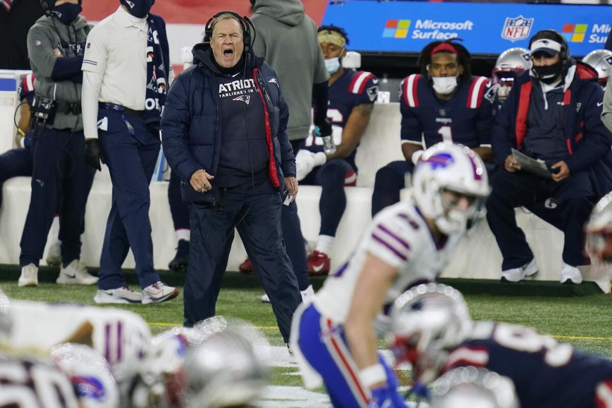 New England Patriots coach Bill Belichick shouts from the sideline at players on the field.