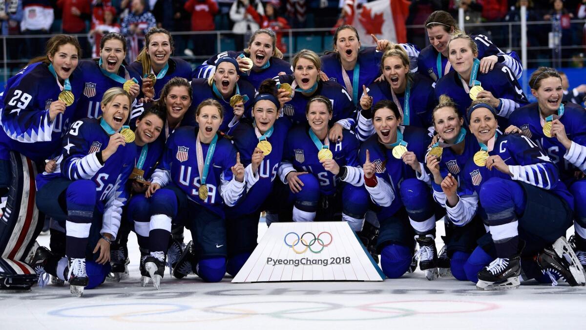 U.S. women's hockey team members pose with their gold medals.