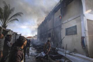 Palestinians try to extinguish a fire at a building of an UNRWA vocational training center which displaced people use as a shelter, after being targeted by Israeli tank shill in Khan Younis, southern Gaza Strip, Wednesday, Jan. 24, 2024. (AP Photo/Ramez Habboub)