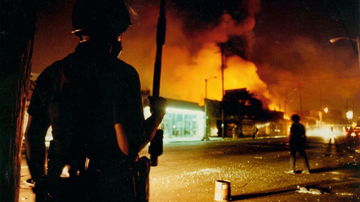 An LAPD officer guards the intersection at Central and 46th Street during the 1992 riots.