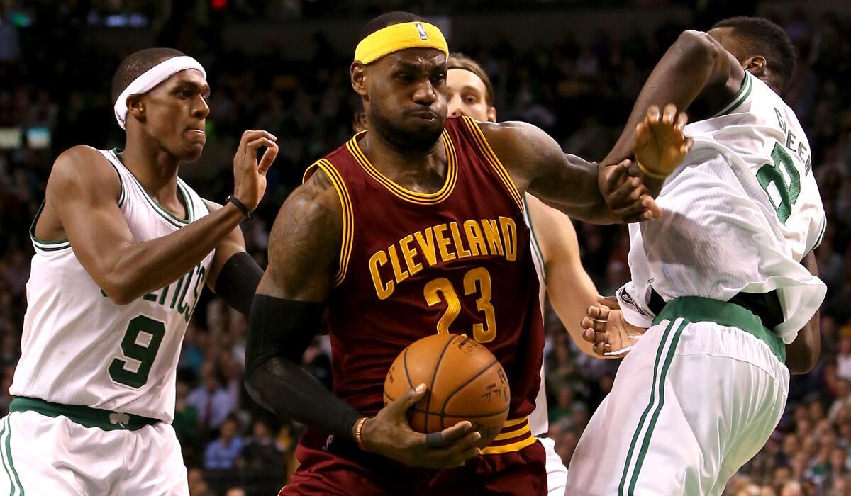 Cavaliers forward LeBron James splits the defense of Celtics point guard Rajon Rondo, left, and forward Jeff Green on a drive to the basket Friday night at TD Garden in Boston.